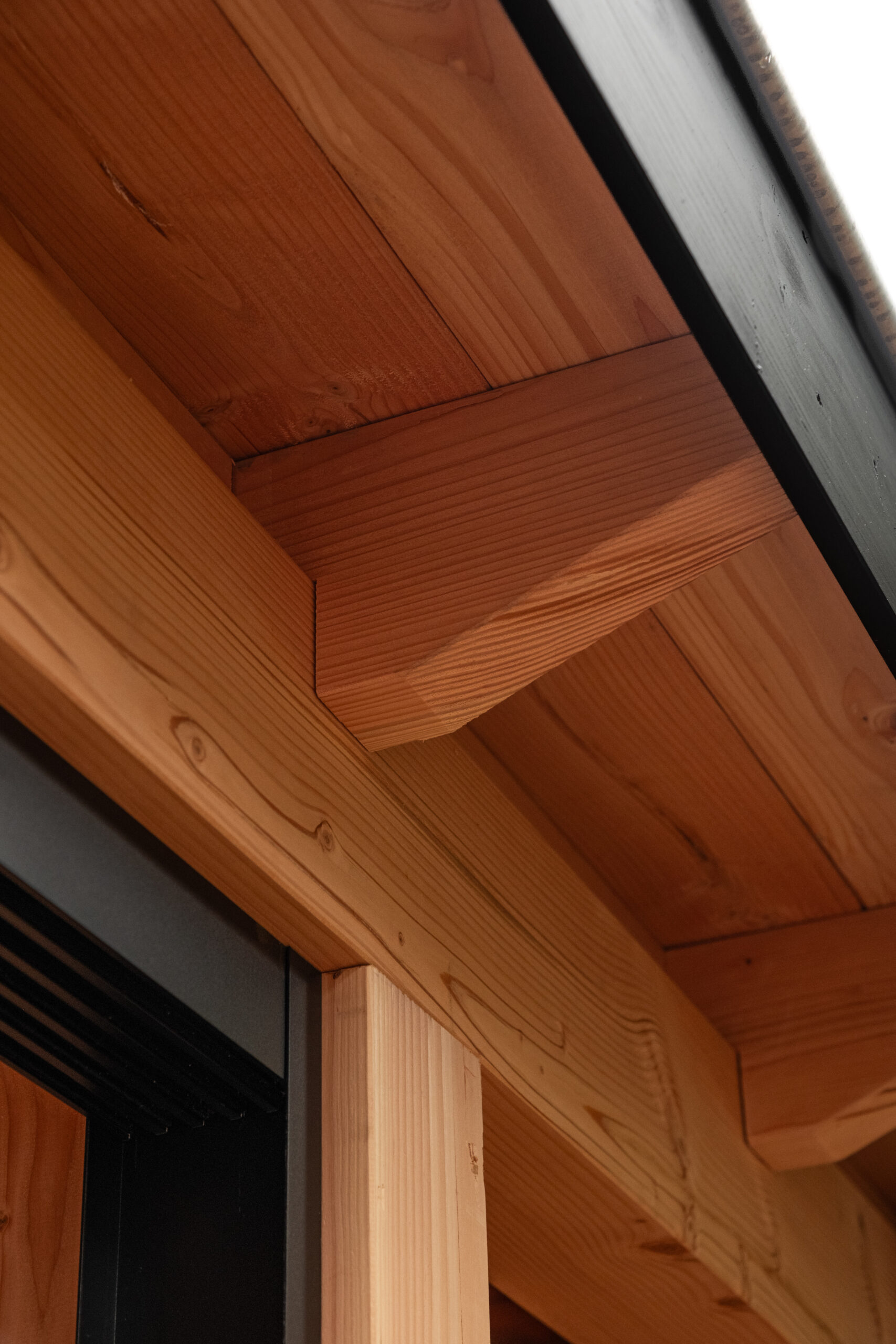 Detailopname van het houten gebint, de overstekken en de dakrandafwerking van de veranda in Ede door BG Buitenverblijven