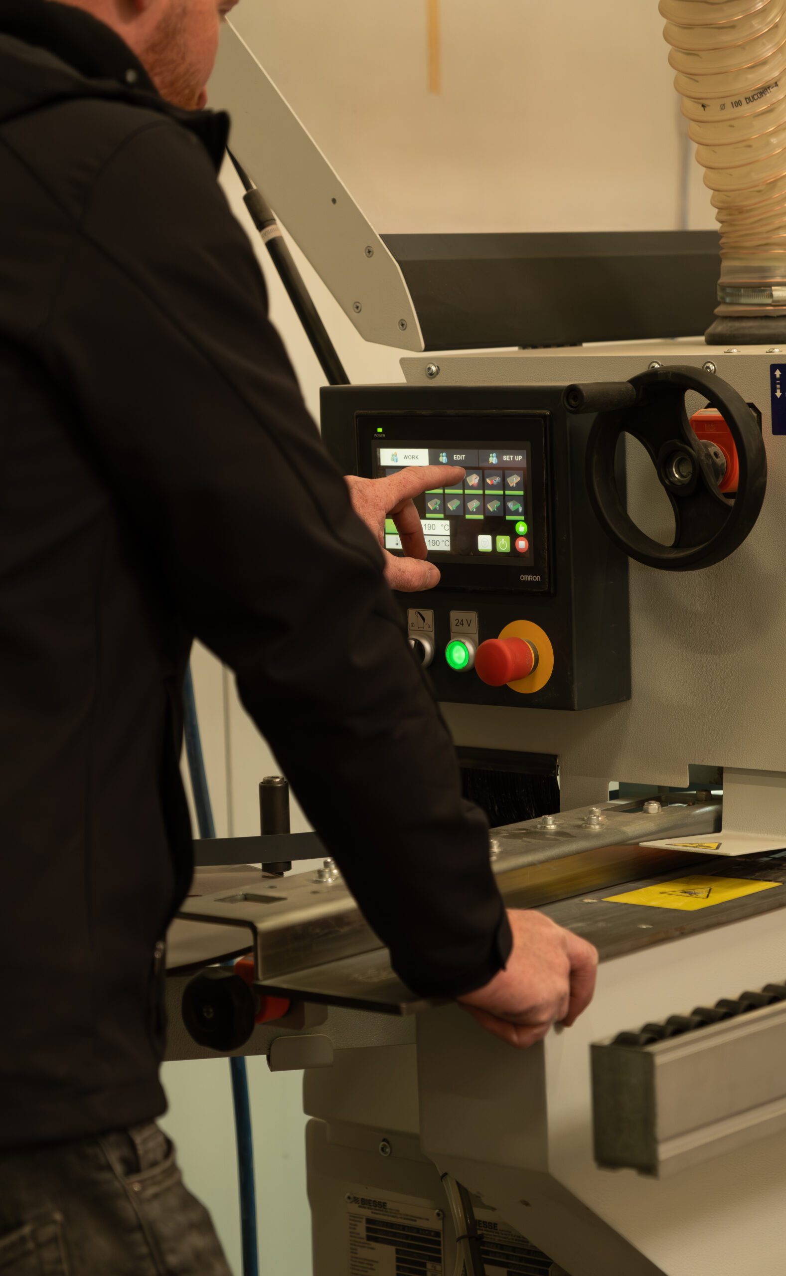 Interieurbouwer van Kardol bedient het digitale scherm van een professionele kantenaanlijmmachine in de werkplaats