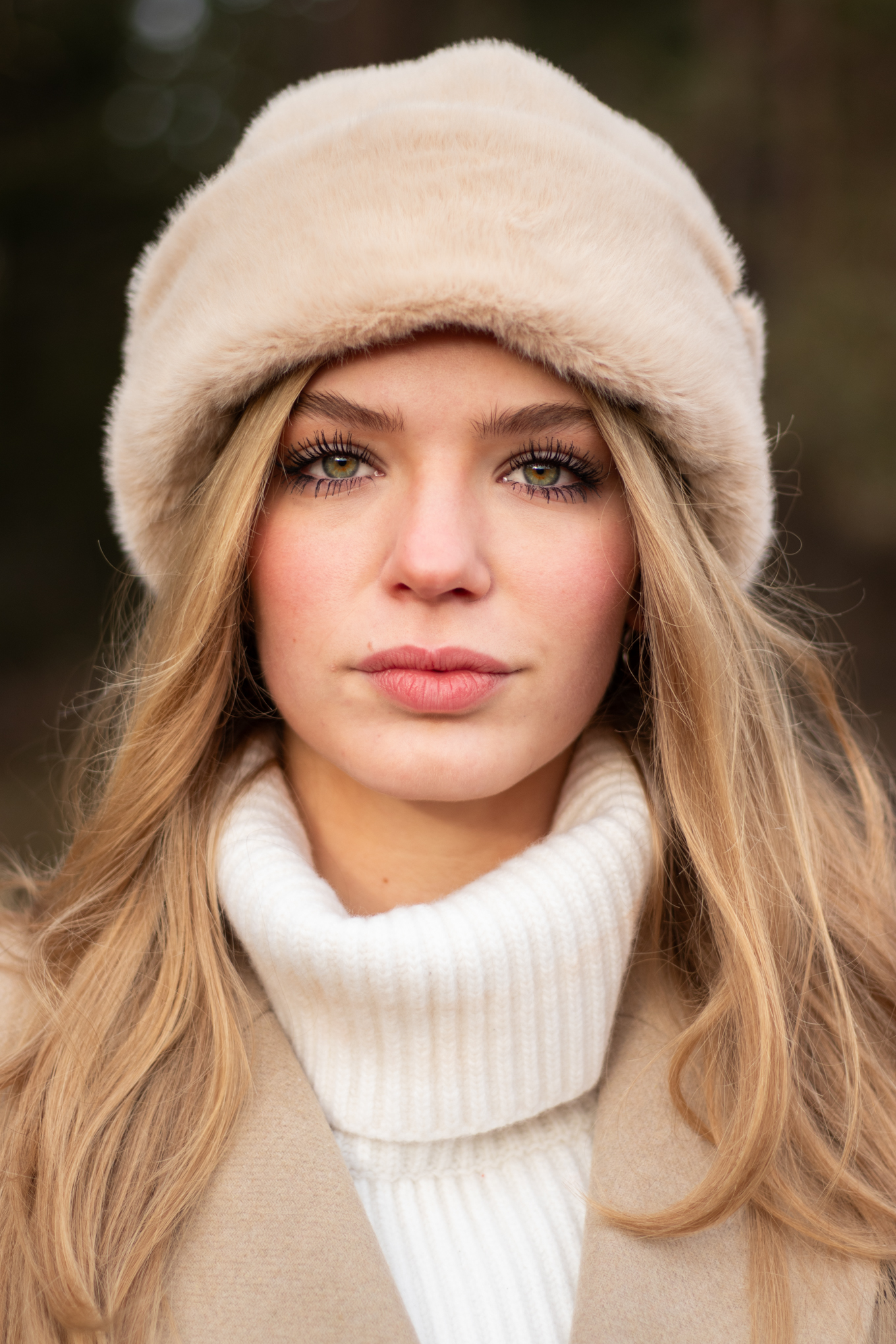 Close up portret van model Kirsten met een beige bontmuts en witte coltrui tijdens een Ivory and Woods shoot in Utrecht